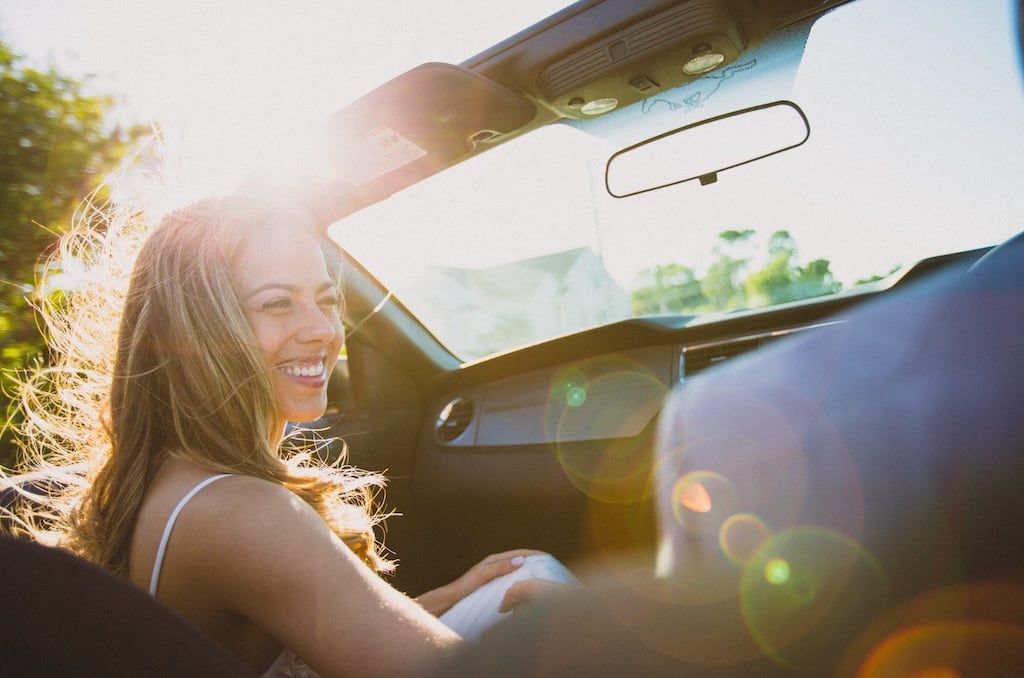 Girl smiling in a convertible car