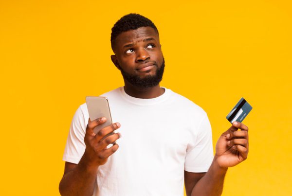 Man with phone and credit/ debit card
