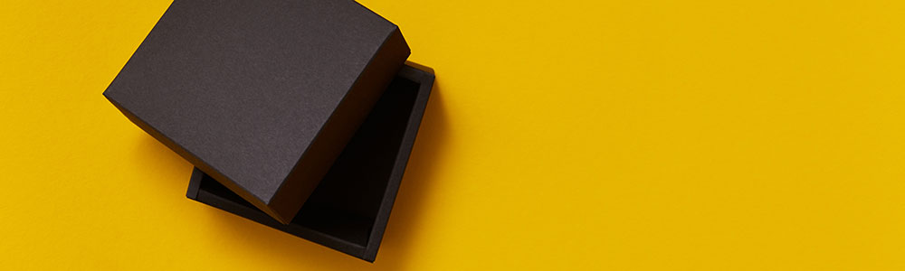 Black box, opened, isolated against mustard yellow background