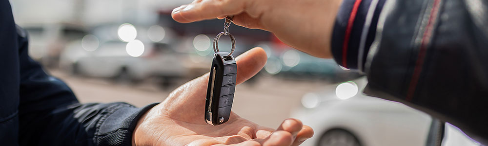 Two male hands exchanging car key fob