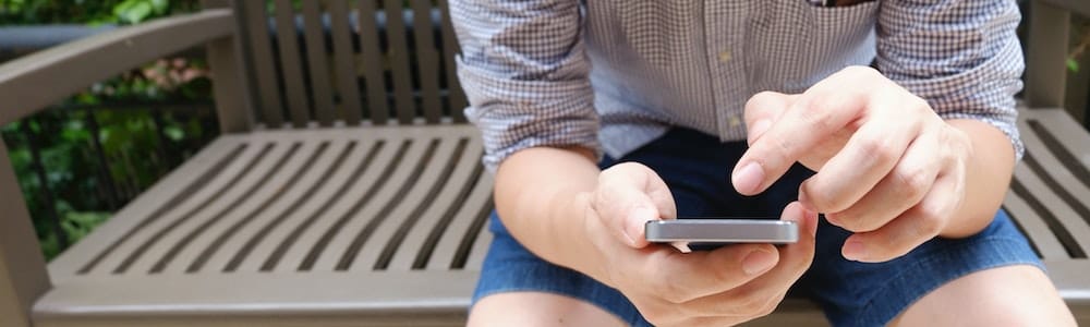 Person in checked shirt using an Android phone