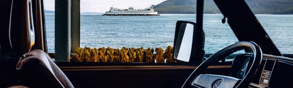 Looking through a car window to the sea and a ship