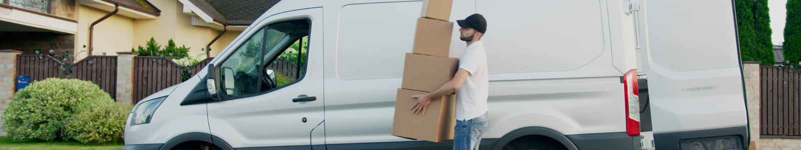 Man carrying boxes near van