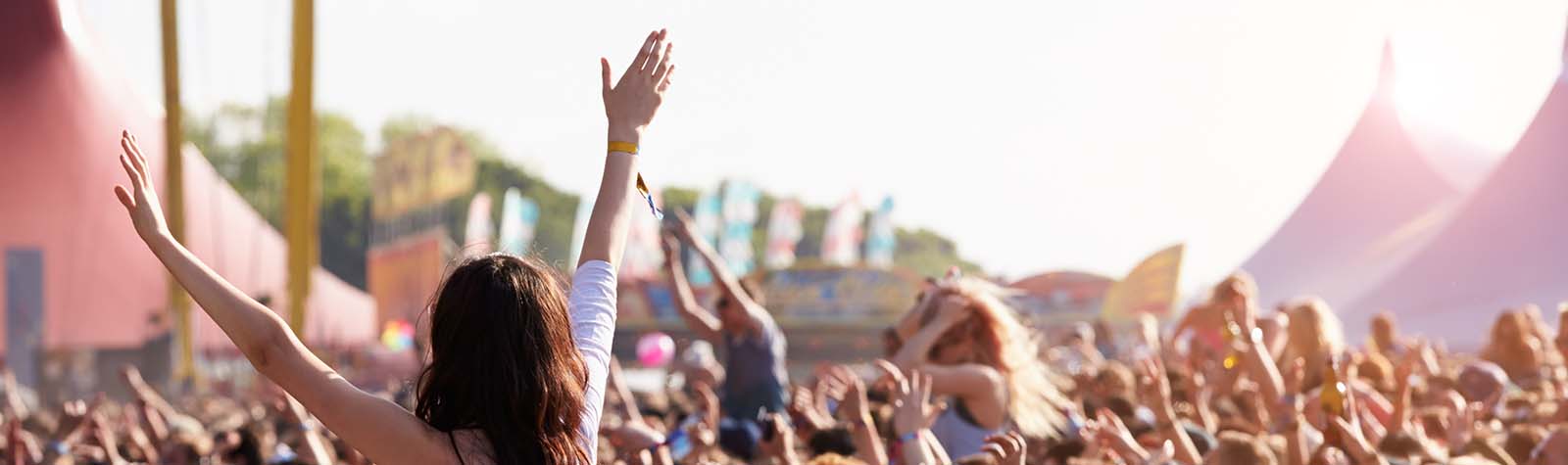 Crowds enjoying themselves at outdoor music festival. Some of them used short term car insurance to get there