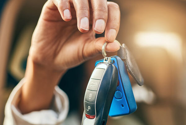 Woman's hand holding the key fob to a car