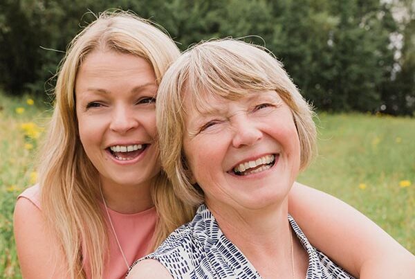 Mature mother and adult daughter smiling on a day out made possible by day insurance
